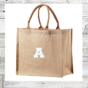 May include: A brown burlap tote bag with a white letter A embroidered on the front.