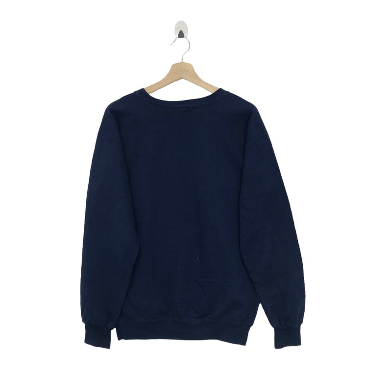 K&ouml;nnte beinhalten: Ein marineblauer Pullover mit langen &Auml;rmeln und einem Rundhalsausschnitt.