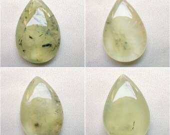 May include: Four teardrop-shaped green gemstones with black inclusions. The gemstones are polished and have a smooth, glossy finish.