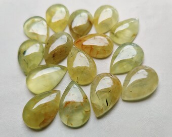 May include: A collection of 15 teardrop-shaped green and yellow gemstone cabochons with inclusions. The stones are translucent and have a variety of patterns and colors.