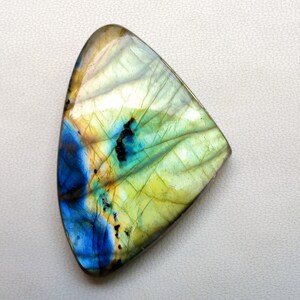 May include: A triangular, iridescent labradorite gemstone with a blue, green, and yellow color scheme.
