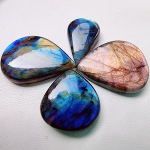 May include: Four teardrop-shaped labradorite gemstones in shades of blue, green, and brown with iridescent shimmer.