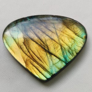 May include: A triangular, iridescent labradorite gemstone with a yellow, green, and blue color pattern.