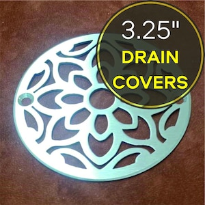 May include: A 3.25 inch diameter silver drain cover with a decorative floral design.  The cover is made of metal and has a circular shape.