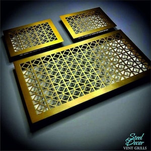 Op de afbeelding: Drie gouden metalen ventilatie roosters met een geometrisch patroon. De ventilatie roosters zijn gemaakt van dun metaal en hebben een glanzende afwerking. Het grootste ventilatie rooster is 50,8 cm bij 76,2 cm. De ventilatie roosters zijn gelabeld met "Steel Decor, Vent Grills".