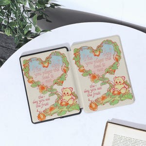 May include: A white and pink illustrated Kindle cover with a heart-shaped design and the text "The day you plant the seed is not the day you eat the fruit".