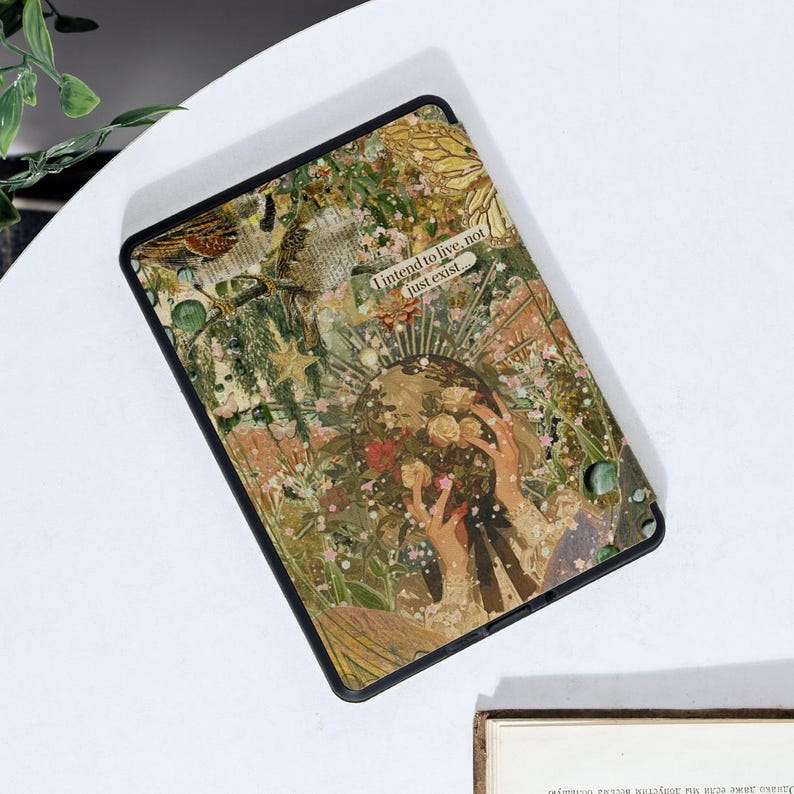 May include: A black e-reader with a collage design featuring flowers, leaves, and the text "I intend to live, not just exist..." The design is in shades of green, brown, and white.
