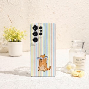 Op de afbeelding: Telefoonhoesje met een verticaal streepjespatroon in pastelkleuren. Het heeft een aquarel illustratie van een rode kat die twee vissen in zijn bek houdt. De hoes is ontworpen voor een smartphone met meerdere cameralenzen.