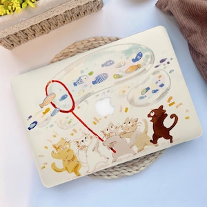 May include: A cream-colored laptop case featuring a whimsical illustration of cats chasing fish in bubbles. The design includes a red net and various colorful fish, creating a playful and artistic aesthetic.