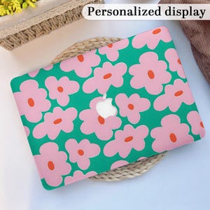 May include: A laptop case with a vibrant floral pattern. The case features large pink flowers with orange centers on a green background. The text "Personalized display" is at the top. The case has a cutout for the Apple logo.