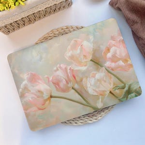 以下が含まれることがあります： 薄い背景にピンクのチューリップが水彩画で描かれた、ラップトップのスキンの画像です。