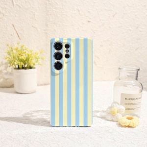 May include: A rectangular smartphone case featuring a vertical striped pattern in alternating light blue and pale yellow colours. The case includes a raised camera cutout section on the upper left side with circular openings for multiple lenses.