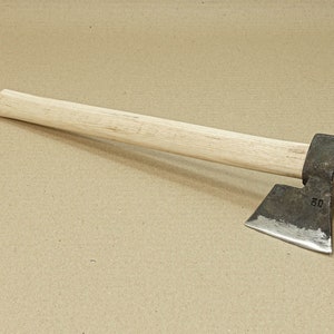 Könnte beinhalten: Eine kleine, handgeschmiedete Axt mit einem Holzstiel. Der Axtkopf ist aus Metall und hat eine leichte Biegung in der Klinge. Der Stiel ist aus hellem Holz und etwa 46 cm lang. Der Axtkopf ist mit der Nummer "50" gekennzeichnet.