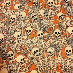 May include: A repeating pattern of skeletons with orange and white colors. The skeletons are all in the same pose, with their arms crossed over their chests. The background is a solid orange color.