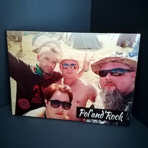 May include: A group of four friends pose for a selfie at a music festival. The photo is printed on a wooden plaque with the words "Pol'and'Rock" in white lettering.