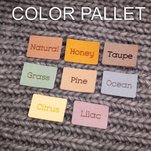 May include: Leather swatches in various colors, including natural, honey, taupe, grass, pine, ocean, citrus, and lilac. The swatches are arranged in two rows on a gray knitted fabric background. The text "COLOR PALLET" is written above the swatches.