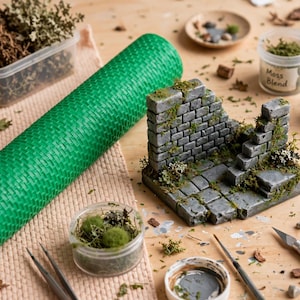 Może przedstawiać: Miniaturowa diorama kamiennych ruin z szarymi ceglanymi ścianami i schodami z zielonymi akcentami mchu, w towarzystwie dużej zielonej teksturowanej maty, pojemników z mieszanką mchu, małego pędzla, nożyka introligatorskiego i kamieni.