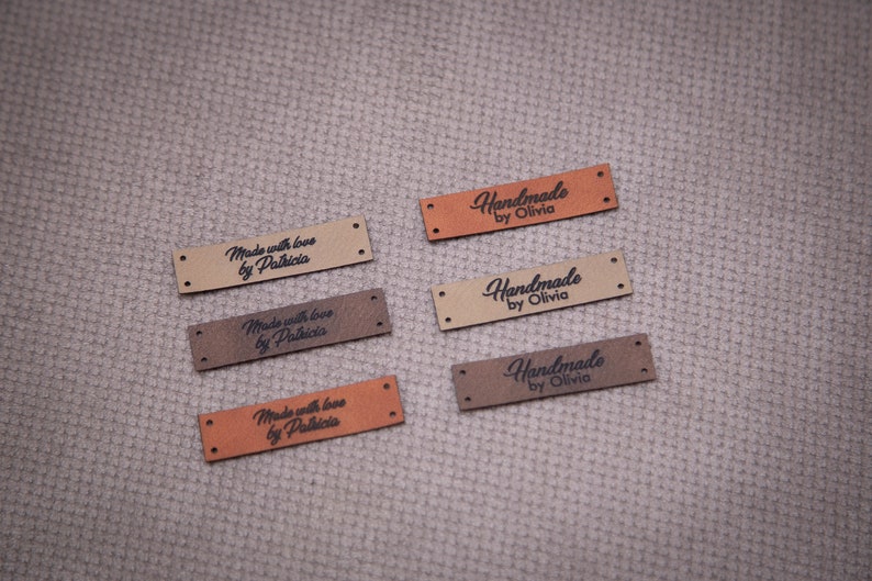 May include: Six brown leather labels with black text. Three labels read "Handmade by Olivia" and three labels read "Made with love by Patricia".