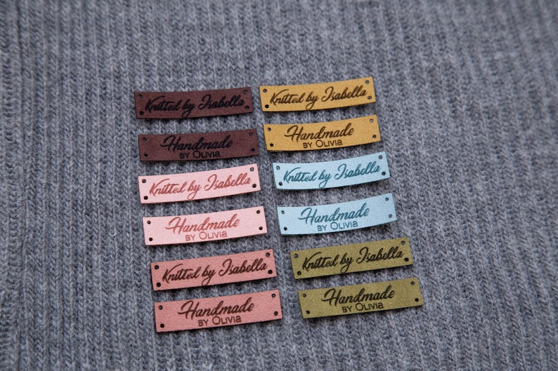 May include: A set of ten fabric labels with different colors and text. The labels read "Knitted by Isabella" and "Handmade by Olivia".