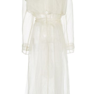 May include: A white sheer trench coat with a belt and long sleeves.