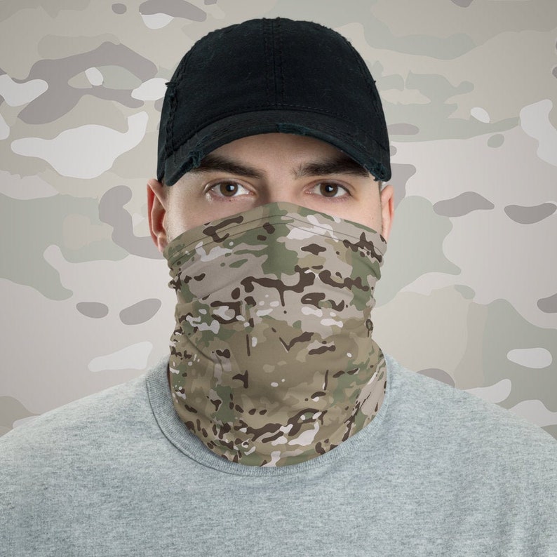 May include: A person wearing a black baseball cap and a camouflage face mask. The mask is made of a soft, breathable fabric and is designed to protect the wearer from the elements.