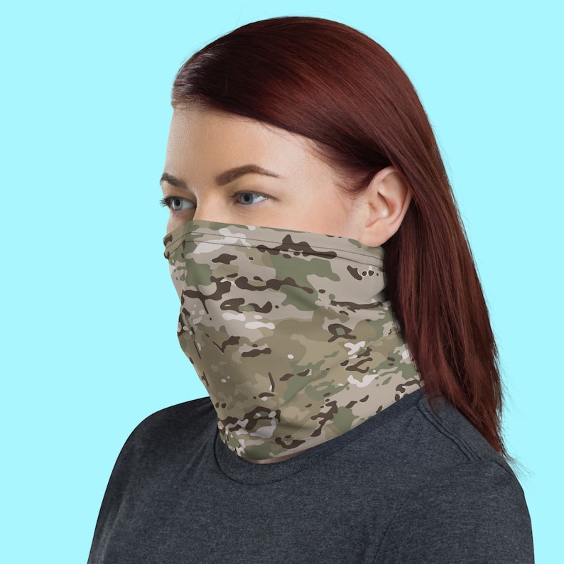 May include: A person wearing a camouflage face covering. The face covering is made of a soft, breathable fabric and is designed to be comfortable to wear. It is perfect for protecting yourself from the elements or for adding a touch of style to your outfit.
