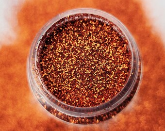 May include: A small clear jar filled with copper glitter. The glitter is loose and has a shimmery finish.