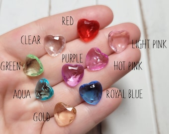 May include: Assortment of heart-shaped clear acrylic charms in various colors, including red, purple, pink, blue, green, aqua, gold, and clear.