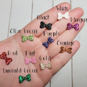 Peut inclure: Assortiment de n&oelig;uds paillet&eacute;s de diff&eacute;rentes couleurs, notamment blanc, noir, magenta, vert olive, violet, orange, rouge, rose, or et vert &eacute;meraude.