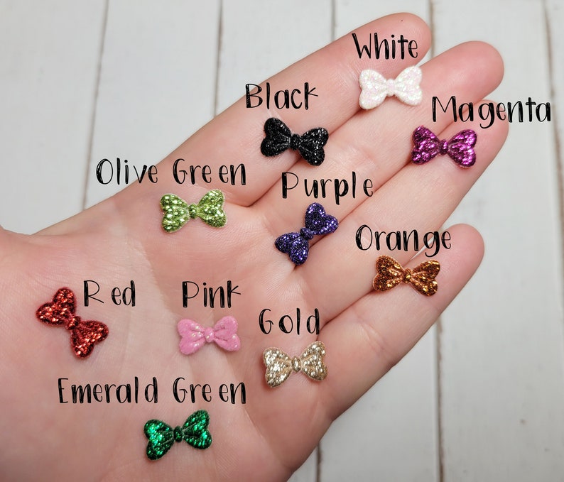Peut inclure: Assortiment de n&oelig;uds paillet&eacute;s de diff&eacute;rentes couleurs, notamment blanc, noir, magenta, vert olive, violet, orange, rouge, rose, or et vert &eacute;meraude.