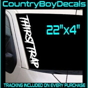 May include: White vinyl decal with the text "THIRST TRAP" in a stylized font. The decal is 22 inches by 4 inches and is shown on a car windshield. The image also shows five different variations of the decal in different fonts.