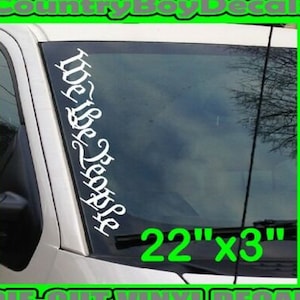 Könnte beinhalten: Weißer Vinyl-Aufkleber mit dem Text "We the People" in einer stilisierten Schriftart. Der Aufkleber ist 22 Zoll mal 3 Zoll groß und ist gestanzt. Der Aufkleber ist auf einer Windschutzscheibe eines Autos zu sehen.