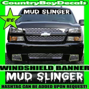 May include: Black truck with a white windshield banner that reads "MUD SLINGER" in dripping letters. The banner is 40 inches by 5 inches.