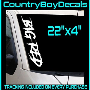 Può includere:  Adesivo in vinile bianco con le parole "BIG RED" in un font stilizzato. L'adesivo misura 22 pollici per 4 pollici ed è mostrato su un parabrezza di un'auto. Il testo "30+ Colori Disponibili" è incluso.