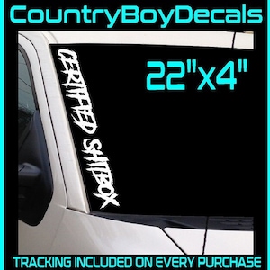 May include: White vinyl decal with the text "CERTIFIED SHITBOX" in a jagged font. The decal is 22 inches by 4 inches and is shown on a car windshield. The text "TRACKING INCLUDED ON EVERY PURCHASE" and "30+ Colors Available" are also visible.