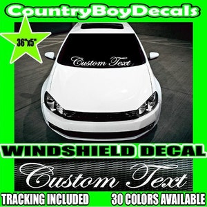 Puede incluir: Calcomanía para parabrisas de coche blanco con el texto "Custom Text" en una fuente cursiva. La calcomanía mide 36 pulgadas por 5 pulgadas. La calcomanía se muestra en un coche blanco.