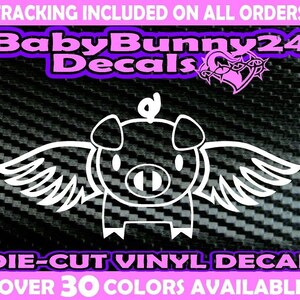 Può includere: Adesivo in vinile bianco di un maiale con le ali. Il maiale è in stile cartone animato e ha un'aureola. L'adesivo dice "Die-Cut Vinyl Decal" e "Over 30 Colors Available".