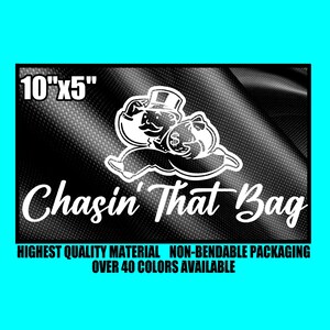 May include: Black rectangular graphic with the text "Chasin' That Bag" and an illustration of a cartoon character with a top hat and money bag. The graphic measures 10" x 5" and includes the text "HIGHEST QUALITY MATERIAL NON-BENDABLE PACKAGING OVER 40 COLORS AVAILABLE."