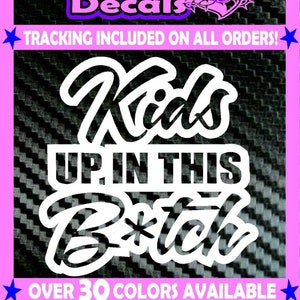 May include: White vinyl decal featuring the text "Kids Up In This B*tch" in a stylised font. The decal is set against a black and white carbon fibre background. The text "Over 30 Colours Available" and "Die-Cut Vinyl Decal" are also visible.