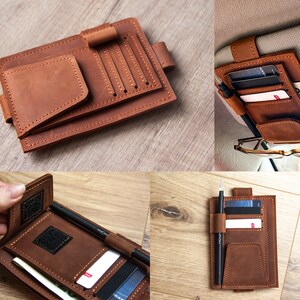 May include: Brown leather car organizer with multiple card slots, a pen holder, and a large pocket. The organizer is designed to be attached to the back of a car seat.