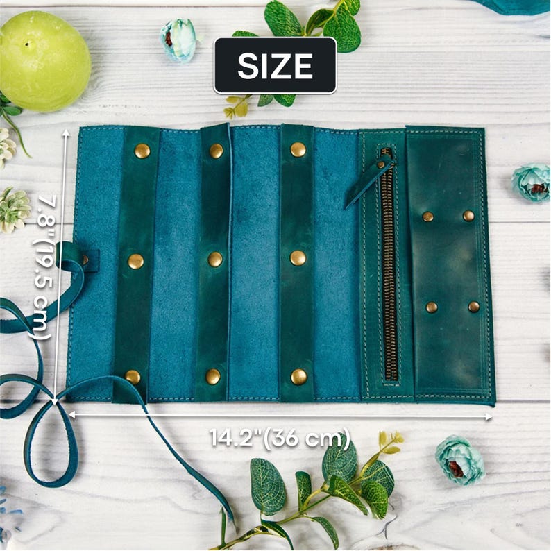 May include: Teal leather jewelry roll with a zipper closure and gold-toned hardware. The roll measures 7.8 inches by 14.2 inches. SIZE is written on a white label.
