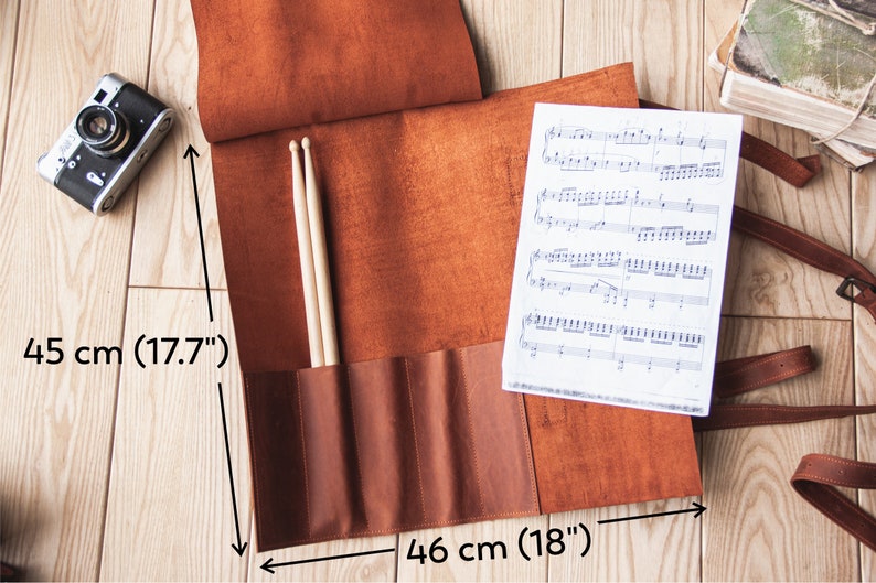 May include: A brown leather roll-up case with straps for carrying sheet music and drumsticks. The case measures 45 cm by 46 cm.