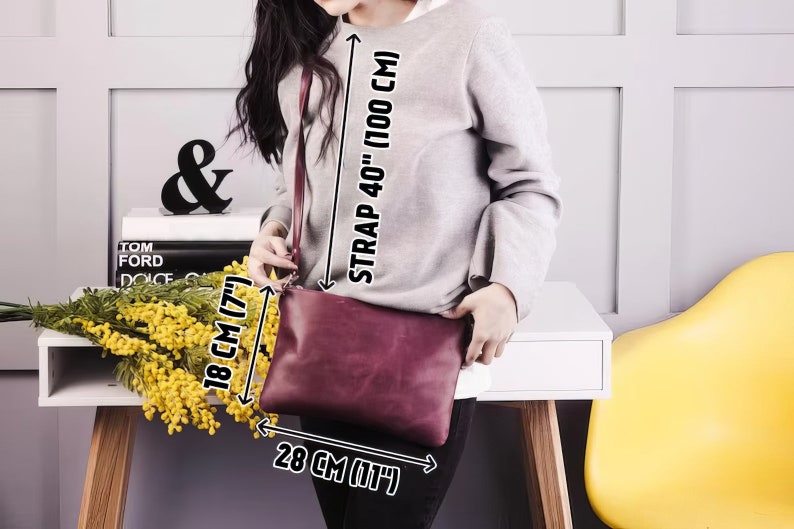 Peut inclure: Un sac &agrave; bandouli&egrave;re en cuir bordeaux avec une longue bandouli&egrave;re r&eacute;glable. Le sac mesure 28 cm de large et 18 cm de haut. La bandouli&egrave;re mesure 100 cm de long.