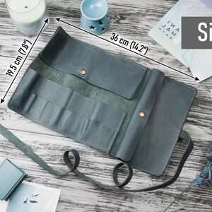 May include: A teal blue leather roll-up case with multiple slots for holding tools or supplies. The case measures 14.2 inches by 7.8 inches.