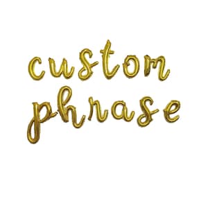 May include: Gold foil letter balloons spelling out the phrase "custom phrase".