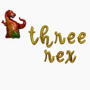 May include: Gold foil letter balloons spelling out "three next" with a red dinosaur balloon.
