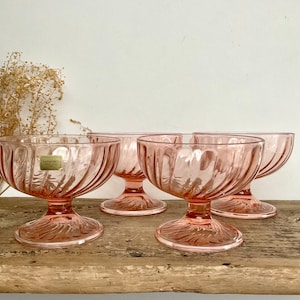Op de afbeelding: Set van vier roze glazen dessertschaaltjes met een geribbeld ontwerp en een voet. De schaaltjes zijn van het merk Luminarc.