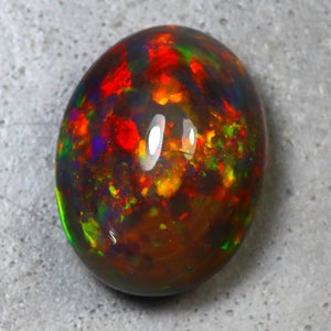 K&ouml;nnte beinhalten: Ein ovaler Opal-Edelstein in Dunkelbraun mit Schimmern in Rot, Gr&uuml;n und Blau.