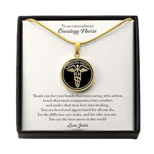 May include: A gold necklace with a black and gold pendant that says "Oncology RN" inside a circle with the word "Oncology" above it. The necklace is in a black box with a message that reads "To an extraordinary Oncology Nurse. Thank you for your hands that turn caring into action, touch that turns compassion into comfort and smiles that turn love into healing. You are loved and appreciated for all you do, for the difference you make, and for who you are. You are the best nurse in the world. Love, Julia."