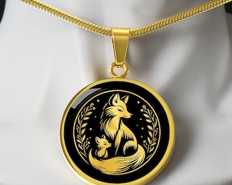 May include: A gold necklace with a round pendant featuring a black silhouette of a mother fox and her kit. The pendant has a gold border and a black background with a floral design.